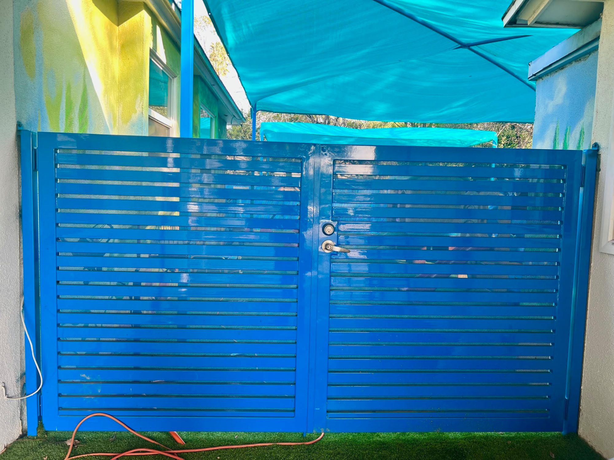 Bright blue double pedestrian gate with horizontal slats and lever lock