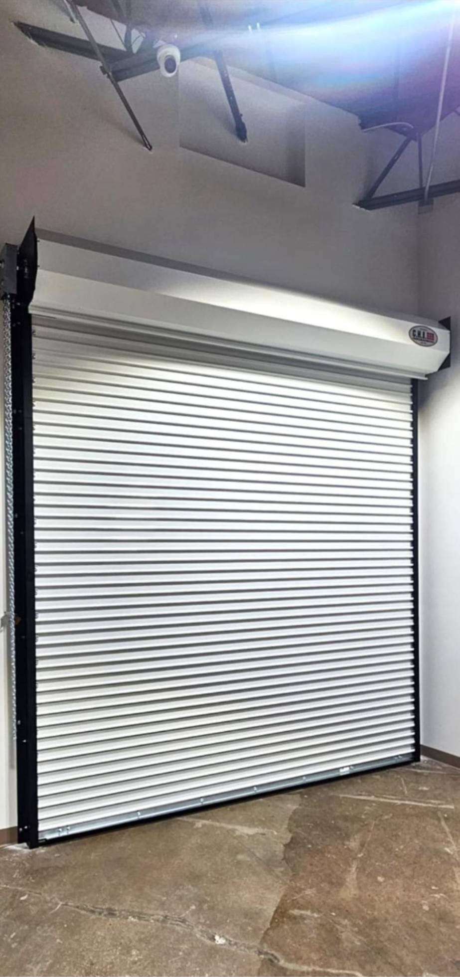 White steel coiling roll-up door installed inside a commercial building