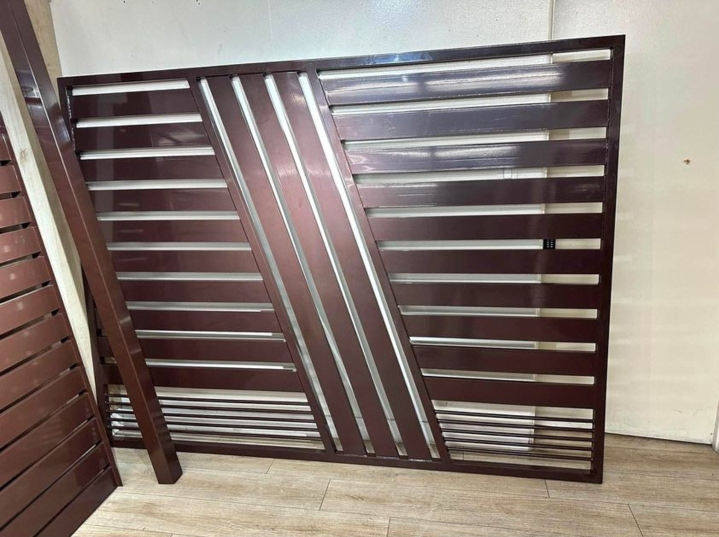 Brown fence panel with horizontal and diagonal slats before installation