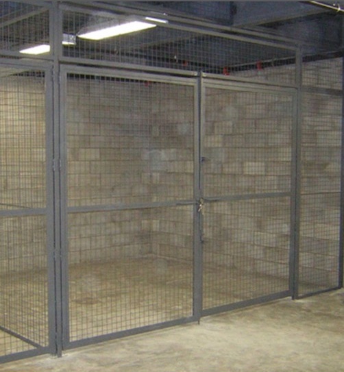 Gray wire mesh storage cages with a padlock hasp in a basement storage area